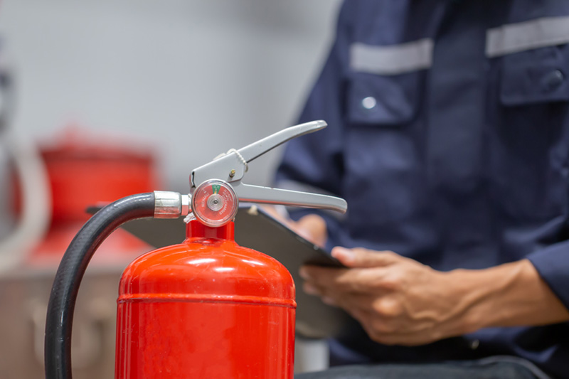 service tech inspects fire extinguisher